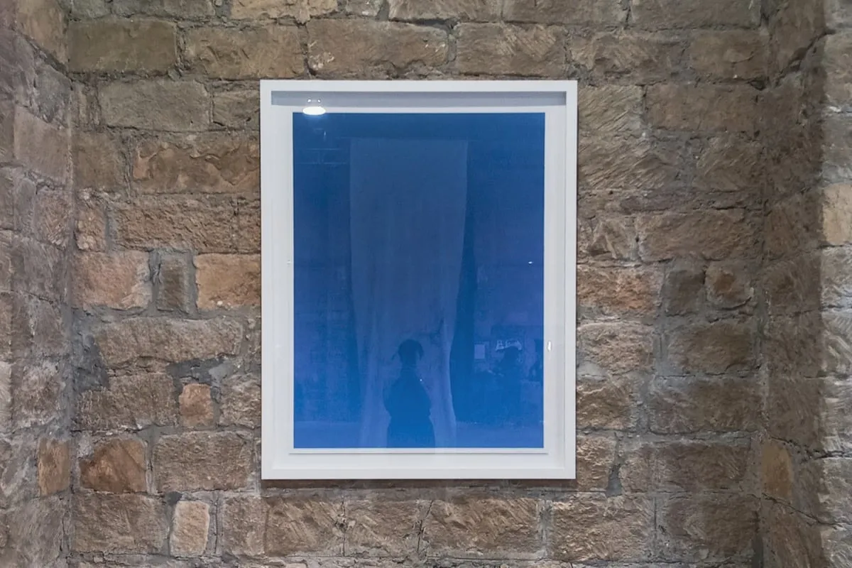 Installation view from RE:SOURCE group exhibition showing The Blue artwork of Zarema Khalilova displayed on a stone wall in Limassol, Cyprus