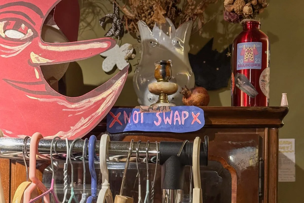 Old fashion closet with hand-writtent sign and decorations on the back, shelves with hangers on the front