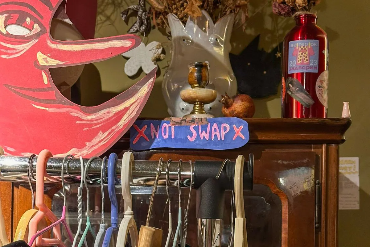 Old fashion closet with hand-writtent sign and decorations on the back, shelves with hangers on the front